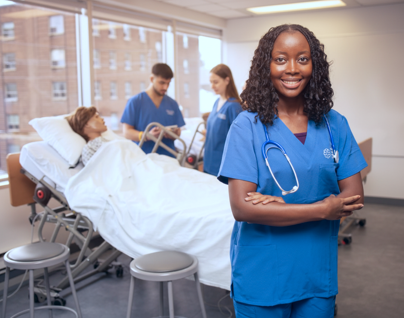 PSW student in blue scrubs smiling